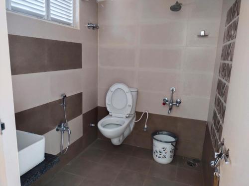 a bathroom with a toilet and a tub and a sink at NKP Residency in Alāndurai