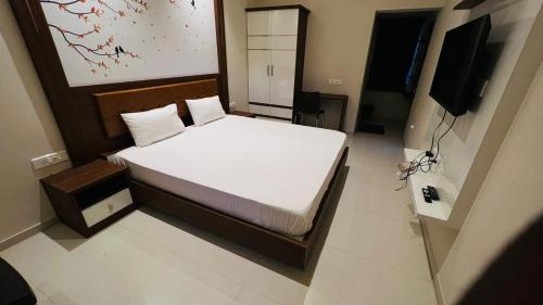 a small bedroom with a bed and a television at NKP Residency in Alāndurai