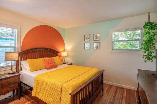 a bedroom with a bed with a yellow blanket and two windows at Hello Sunshine OC minutes to Disneyland-Family Friendly in Fullerton
