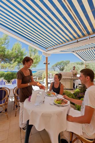 un groupe de personnes assises à une table en train de manger dans l'établissement Hotel Club Marina Viva, à Porticcio