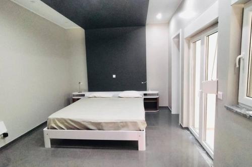 sypialnia z białym łóżkiem i czarną ścianą w obiekcie Bliss Apartments T0 - Maria (On the beach) w mieście Mindelo