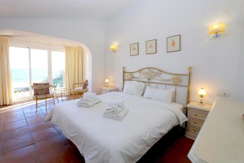 a bedroom with a large bed with towels on it at Townhouse SEASCAPE in Estepona