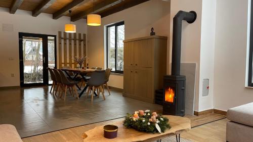 a living room with a fireplace and a dining table at A Sziget in Izvoare