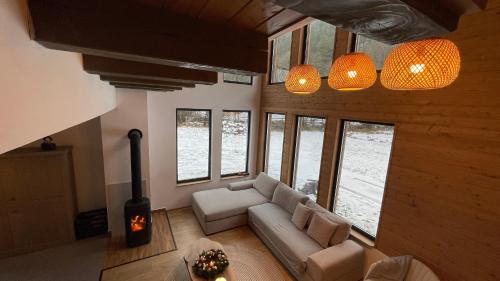 sala de estar con sofá y algunas ventanas en A Sziget, en Izvoare