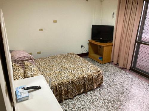 ein Hotelzimmer mit einem Bett und einem Flachbild-TV in der Unterkunft 東海旅社 有匯款才會留房喔 in Shuili