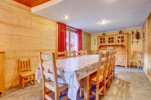 une cuisine et une salle à manger avec une table et des chaises dans l'établissement l'OUTO, à Morzine