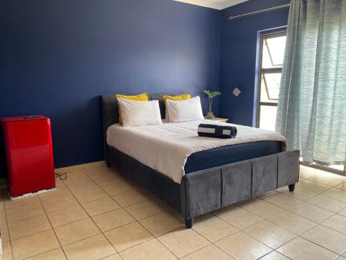 a bedroom with a bed with a blue wall at Witbank Apartments in eMalahleni
