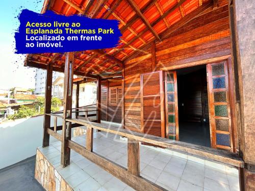 un bâtiment en bois avec un panneau en face de celui-ci dans l'établissement Casa Para Temporada - Com Acesso ao Rio Thermal, à Rio Quente