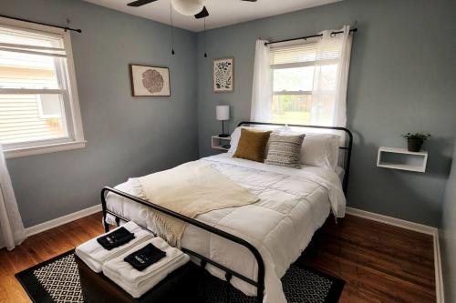 a bedroom with a bed in a room with two windows at Cozy house near Lake Erie, 10 minutes to Downtown. in Cleveland