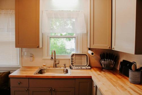 uma cozinha com um lavatório e uma janela em Cozy house near Lake Erie, 10 minutes to Downtown. em Cleveland