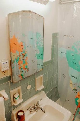 a bathroom with a sink and a shower with a mirror at Cozy house near Lake Erie, 10 minutes to Downtown. in Cleveland