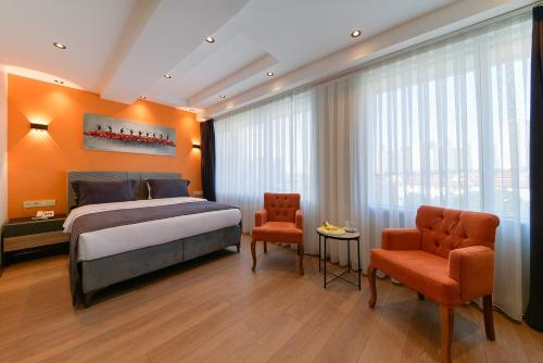 イスタンブールにあるRise Inn Hotelのベッドルーム1室(キングサイズベッド1台、椅子2脚付)