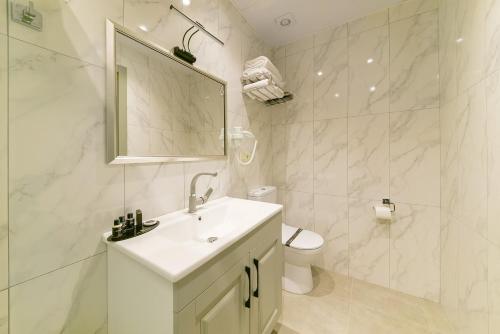 Baño blanco con lavabo y aseo en Rise Inn Hotel, en Estambul
