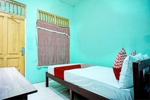 a small bedroom with a bed and a window at OYO 93298 Barito House in Pematangsiantar