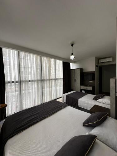 - une chambre avec 2 lits et une grande fenêtre dans l'établissement Comfort Başaran OTEL, à Antalya