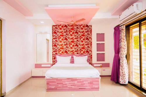 a bedroom with a bed and a red wall at Nature Sweethome Starlight villa in Panchgani