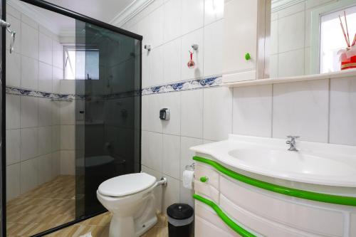 a bathroom with a toilet and a sink and a shower at Apartamento na praia - Canto da Sereia in Piçarras