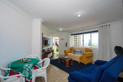 Apartamento na praia - Canto da Sereia في بيساراس: غرفة معيشة مع أريكة زرقاء وكرسي اصفر