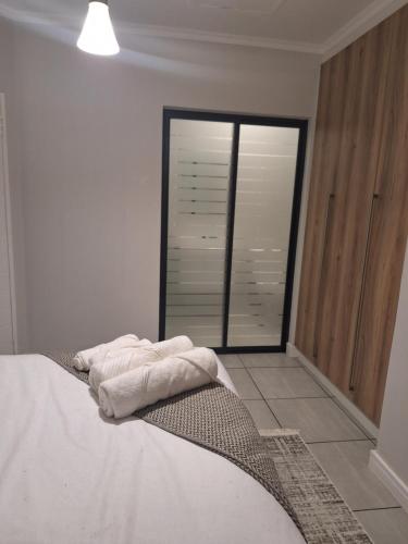 a bedroom with a bed and a large window at Prunell in midrand in Midrand