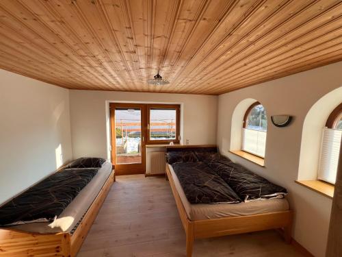 twee bedden in een kamer met een houten plafond bij Apartment Lopez in Sankt Johann in Tirol