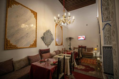 a dining room with a table and a chandelier at Palais Chahd Luxury in Fès