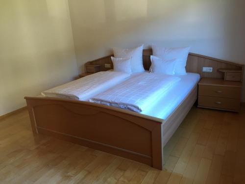 Bett mit weißer Bettwäsche und Kissen in einem Zimmer in der Unterkunft Bizau 361 in Bizau