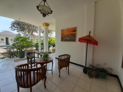 a living room with a table and chairs and a view at Puri Kesumayudha House 2 in Tanjungkarang