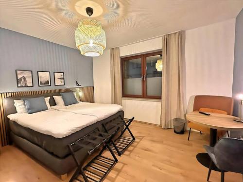 ein Schlafzimmer mit einem Bett, einem Tisch und einem Stuhl in der Unterkunft Urban & Chic: 2Bdr, Parkplatz in Witten