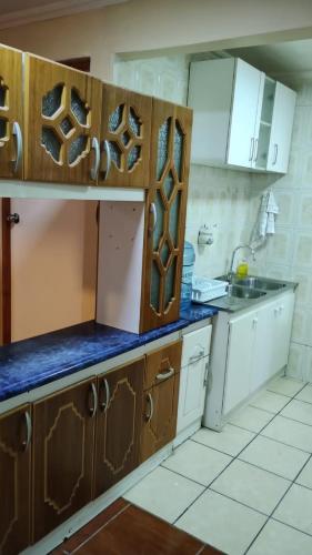 a kitchen with white cabinets and blue counter tops at Casa interior Playa Brava in Iquique