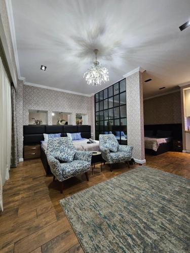 a living room with a bed and two chairs at Old Tbilisi Apartments1 in Tbilisi City