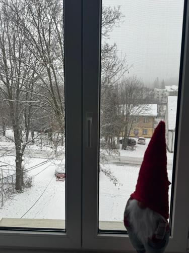 a person wearing a santa hat sitting in front of a window at LV Luxury Apart - One minute away from train station in Predeal
