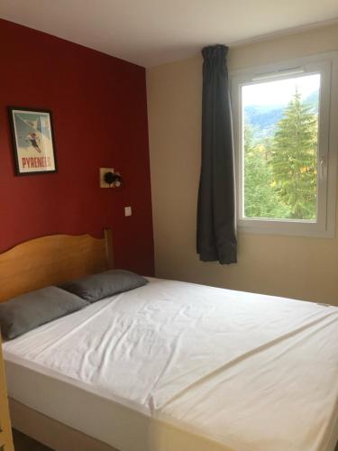 a bed in a bedroom with a window at Appartement à Saint Lary Soulan, 4-5 pers, à 150m des télécabines et du village in Saint-Lary-Soulan