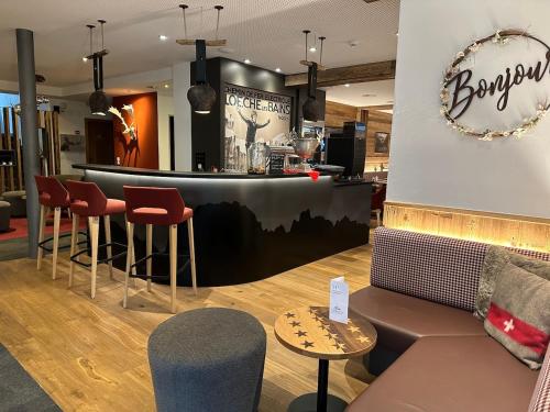 a bar in a store with chairs and a couch at Therme 51° Hotel Physio & Spa in Leukerbad