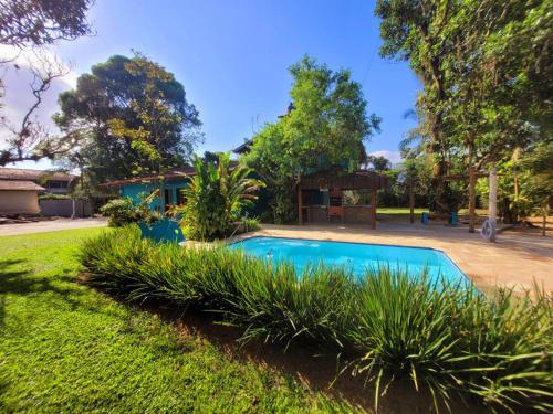 a swimming pool in the yard of a house at Suítes Barra da Lagoa in Ubatuba
