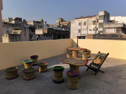 einer Gruppe von Hockern und einem Tisch auf dem Dach in der Unterkunft Pink City Backpackers in Jaipur
