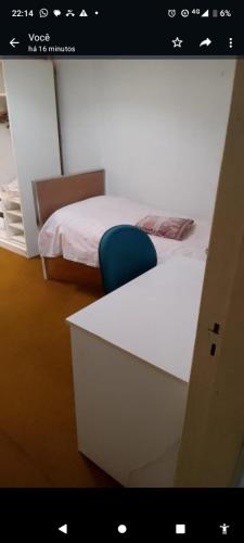 a room with a bed and a desk with a blue chair at Mansão bairro nobre in Campinas