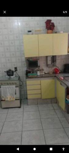 a kitchen with yellow cabinets and a counter top at Mansão bairro nobre in Campinas
