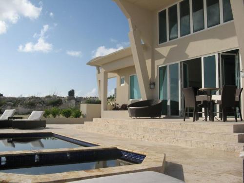 ein Haus mit einem Pool und einer Terrasse in der Unterkunft Sky Beach Club Villa Waterfall 2 home in Governors Harbour