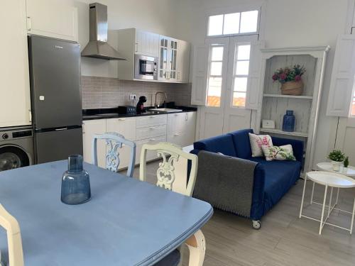 eine Küche und ein Wohnzimmer mit einem blauen Tisch und Stühlen in der Unterkunft Meriga in Agulo