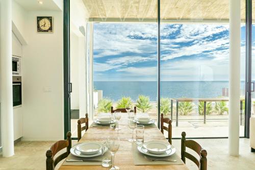 a dining room with a table with a view of the ocean at CasaCarbonito in Carboneras