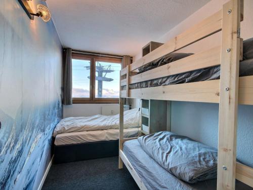 une chambre avec deux lits superposés et une fenêtre dans l'établissement Appartement 3 pièces au pied des pistes avec terrasse et WiFi à Plagne Centre - FR-1-455-244, à La Plagne Tarentaise