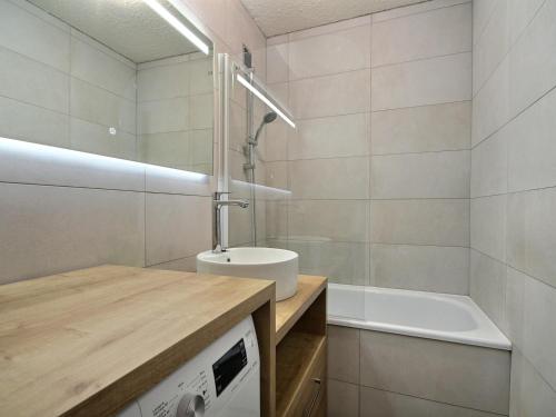 une salle de bain avec un lavabo et une baignoire dans l'établissement Appartement 3 pièces au pied des pistes avec terrasse et WiFi à Plagne Centre - FR-1-455-244, à La Plagne Tarentaise