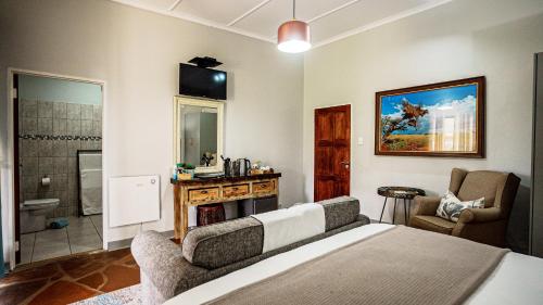 a bedroom with a bed and a bathroom at Jonkershoek Guest Farm in Kimberley