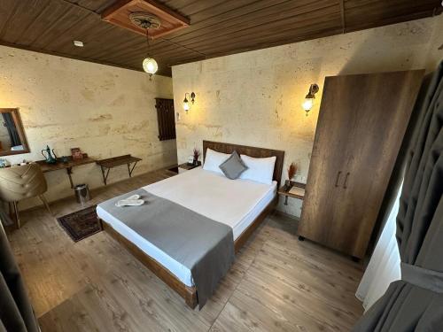 a bedroom with a large bed and a desk at Virtus Cappadocia Hotel Göreme in Goreme