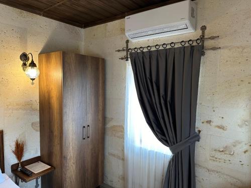 a bedroom with a curtain and a window at Virtus Cappadocia Hotel Göreme in Goreme