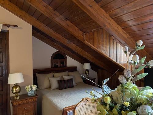 カラブリタにあるPorfyra Luxury Guesthouseの木製の天井のベッドルーム1室(ベッド1台付)