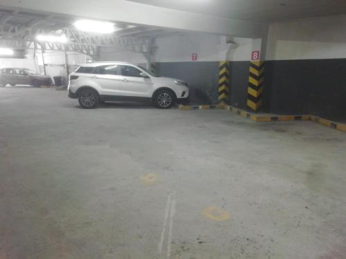 ein weißes Auto, das in einem Parkhaus parkt in der Unterkunft Hotel Presidente Internacional in Guayaquil