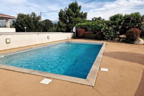 une piscine avec de l'eau bleue dans une cour dans l'établissement Appartement en rez de jardin., à Porto-Vecchio