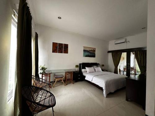 a bedroom with a bed and a desk in it at Roemah Uli Cirebon in Cirebon