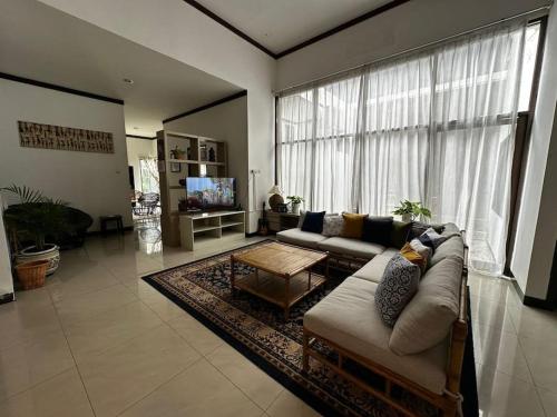 a living room with a couch and a large window at Roemah Uli Cirebon in Cirebon